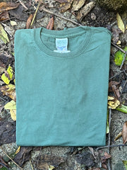 Organic cotton Green t-shirt on a ground surface with leaves and twigs
